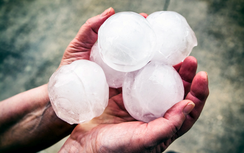 Woman holding group of very big hailstones. Photo 649666268 © Gregory_DUBUS | iStockPhoto